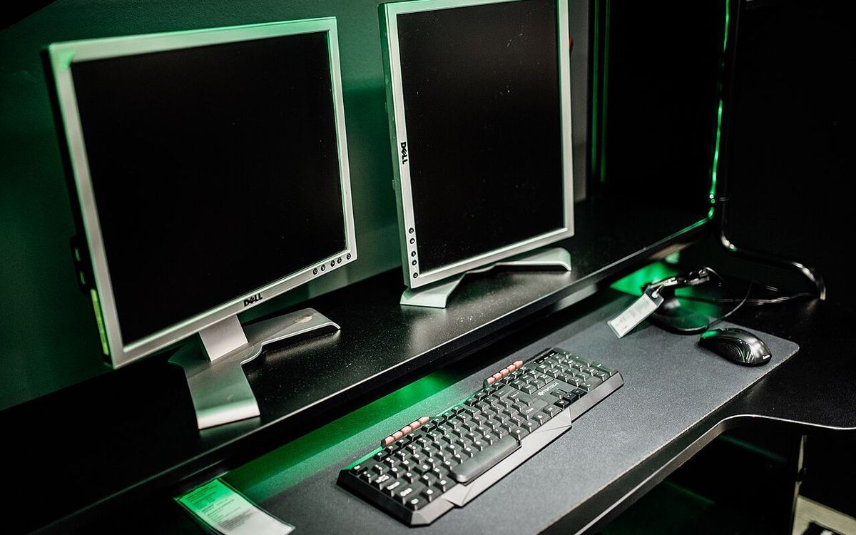 Dual monitor setup in a gaming room with keyboard and mouse in focus