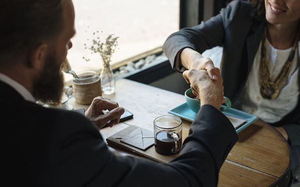 Business agreement handshake at coffee shop
